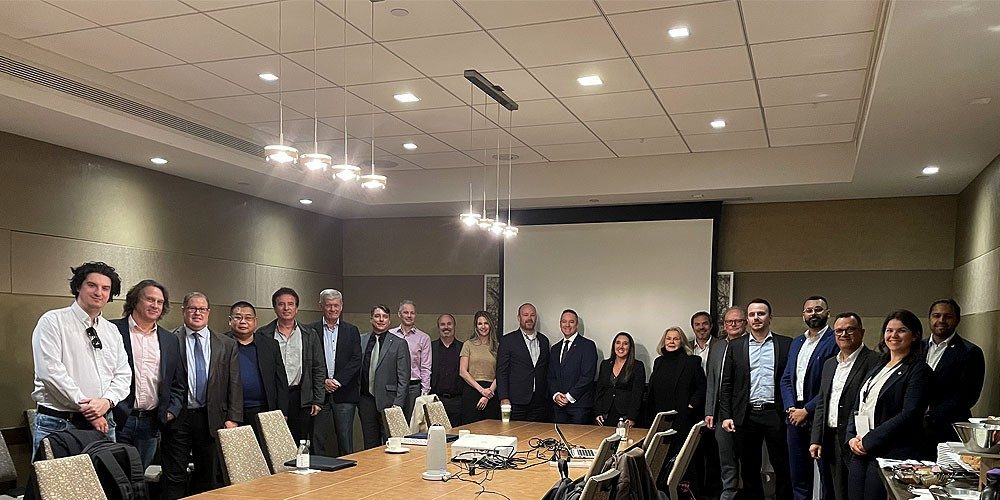 Participants gathered around a conference room table posing for a group photo